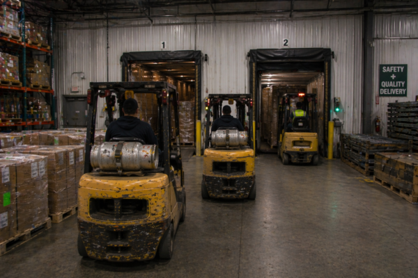Busy Warehouse With Forklifts And Docks - Brazos Manufacturing
